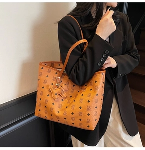 Borsa tote marrone con motivo a orsetti portata a spalla da modella su scale