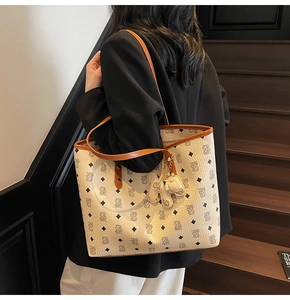 Vista laterale del modello con borsa tote beige con stampa orso e ciondolo morbido