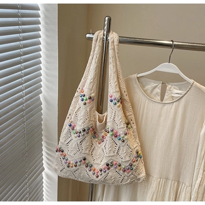 Detail of beige crochet tote bag featuring colorful beadwork wave patterns and open knit