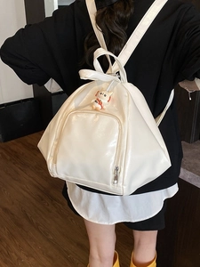 White glossy PU leather backpack with a cat doll pendant shown on a model from behind