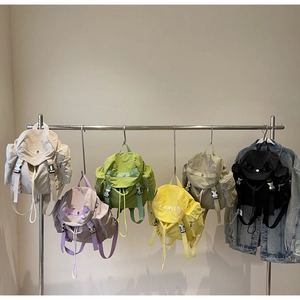 Detailed display of multiple nylon backpacks in various colors on a metal display rack