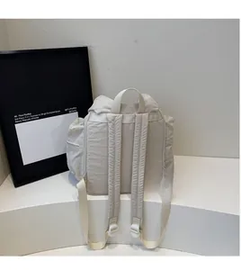Detail of ergonomic padded shoulder straps and side pockets on a beige nylon backpack
