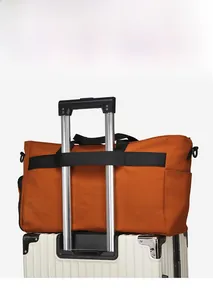Caramel travel duffel bag with a back strap securely attached to a luggage handle