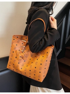 Grande borsa tote marrone con motivo a orso e ciondolo a cucciolo sulla modella