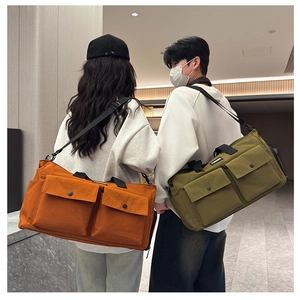 Detail of travel bags in orange and olive with front snap pockets and adjustable straps