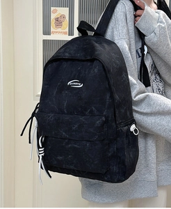 Detail view of the black vintage canvas backpack with side buckles and logo print