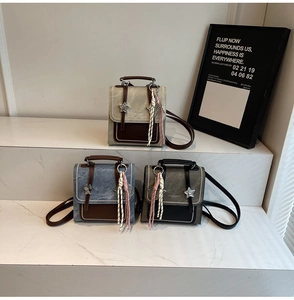 Detailed shot of retro small square backpacks with star hardware and tassels in three colors