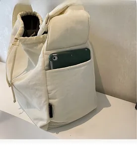 Detail of canvas bag side pocket holding a tablet, showing large storage capacity