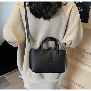 Close-up of black lychee grain leather bucket bag with silver metal ring and handle