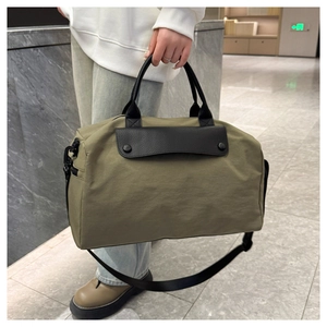 Detail of olive nylon fitness bag with leather flap and detachable shoulder strap