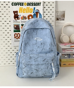 Detailed view of light blue marble pattern backpack with logo and front zipper pocket