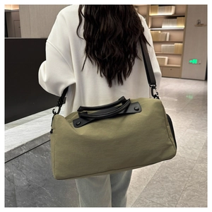 Macro detail of olive green waterproof travel bag showing texture and metal shoulder hooks