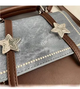 Detailed close-up of blue denim and brown leather patchwork with silver star accent