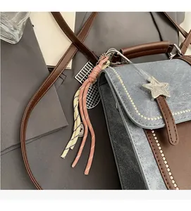 Detail of retro color-block crossbody bag with silver star and braided tassel