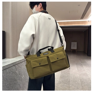 Detail of olive green canvas travel bag with utility pockets and fashion label