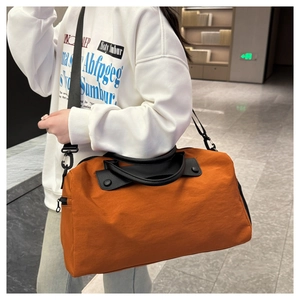 Detail view of large orange gym bag with adjustable strap and reinforced handles