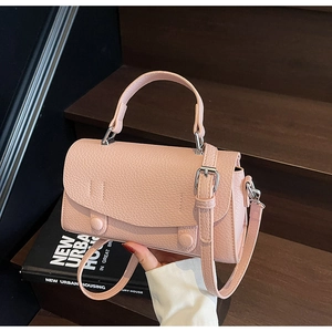 Close-up of pink lychee textured leather mini bag with silver metal buckle and handle