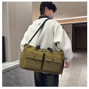 Rear view of an olive green travel duffel bag with dual pockets and a fashion patch