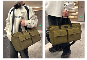 Detail view of large olive green canvas travel bag with front pockets and fashion tag