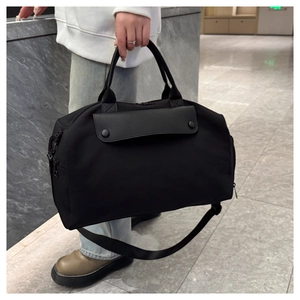 Macro view of black fitness bag with faux leather flap, side zipper, and nylon straps