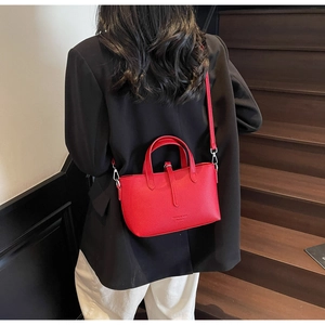 Close-up of bright red lychee leather texture and FASHION BAG embossed logo