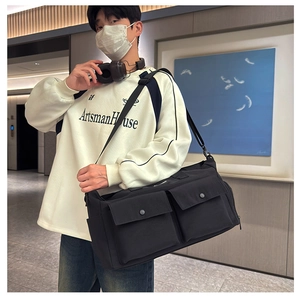 Detail of a large capacity travel bag featuring dual front pockets with snap buttons