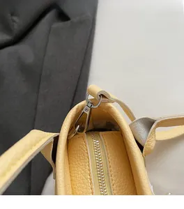 Detail of light yellow lychee grain leather bucket bag with silver hardware and neat stitching