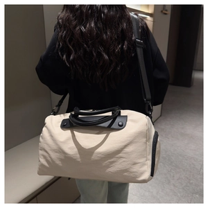 Rear view of a model carrying a large off-white travel bag with black leather handles