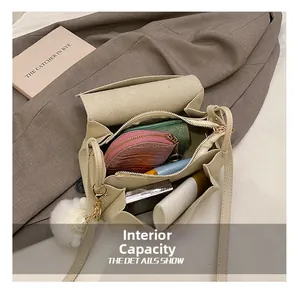 Detail of cream crossbody bag internal capacity with cosmetics and fuzzy charm