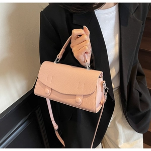 Detail showing soft pink lychee grain leather handbag with adjustable crossbody strap