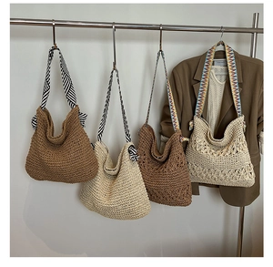 Détail de sacs fourre-tout en paille tissée avec bandoulières à motifs de style ethnique