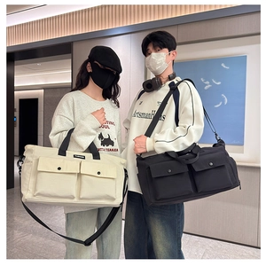 Detailed view of spacious canvas travel bags with front pockets in black and beige tones