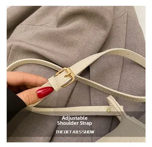 Detail of adjustable white leather strap with golden metal buckle for crossbody bag