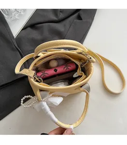 Top view of yellow bucket bag interior showing compartments for phone and cosmetics