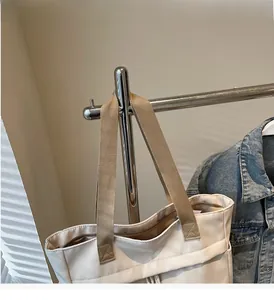Detail view of large canvas tote bag with reinforced handles and secure zipper closure