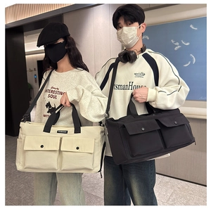 Dual view of large travel duffel bags in beige and black with multi-pocket design