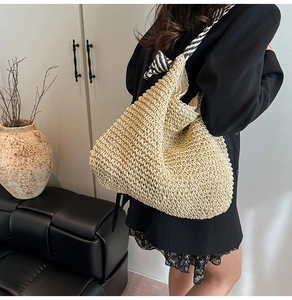 Détail du sac cabas en paille tressée avec bandoulières en corde rayée noire et blanche