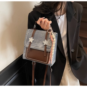 Detail of vintage denim mini backpack with leather trim and white star patterns