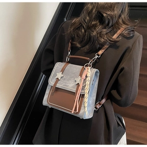 Détail du petit sac bleu clair avec étoiles argentées et pompon sur le mannequin