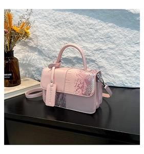 Détail du sac à main rose avec texture peau de serpent et étiquette de mode
