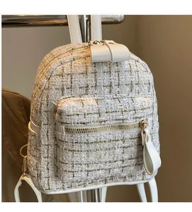 Détail d'un sac à dos en tweed blanc avec fils métalliques dorés et anses en cuir blanc