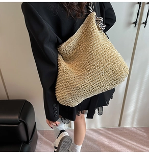 Détail d'un grand sac cabas en paille avec des bretelles rayées noires et blanches
