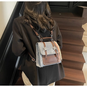 Détail montrant la texture grise vintage et les rivets en étoile sur le sac à dos