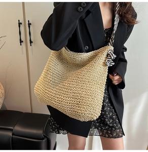 Détail d'un grand sac cabas en paille avec des bretelles en sergé noir et blanc