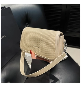 Detailed shot of beige leather and straw woven crossbody bag with fashion lettering