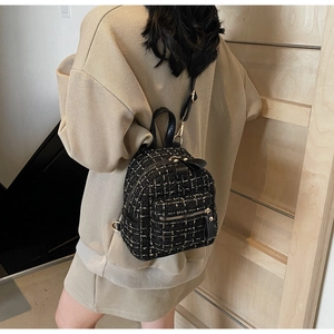 Détail d'un sac à dos en tweed à carreaux avec dorures et bretelles en cuir