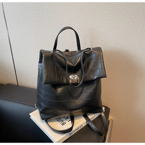 Detalle de la mochila de cuero de cocodrilo negro con hebilla giratoria plateada