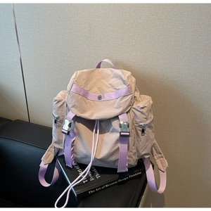 Detail of apricot nylon backpack with purple straps and functional metal buckle