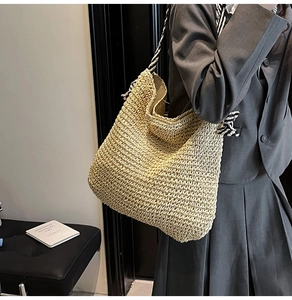 Détail d'un grand sac cabas en paille avec des anses en corde torsadée et texture tressée