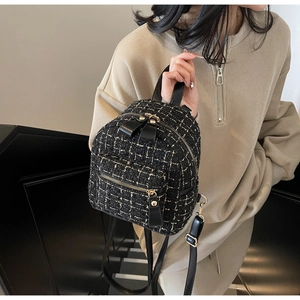Détail du mini sac à dos en tweed avec nœud en cuir et fermetures éclair dorées